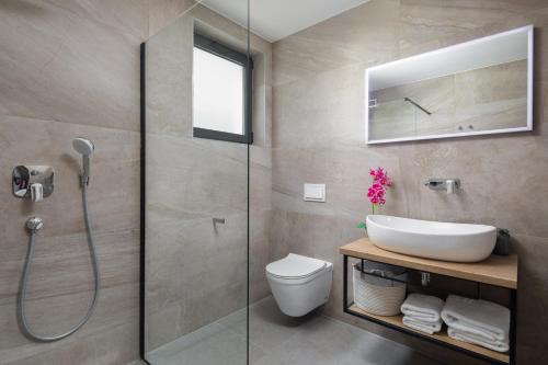 a bathroom with a shower and a toilet and a sink at Luxury Villa IN with Heated Pool in Solin