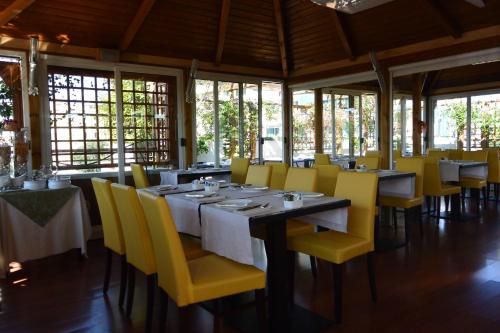 a dining room with tables and yellow chairs at Hotel Metrò in Milan