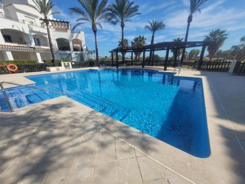 a large blue swimming pool with a gazebo at Casa Gavendy, La Torre Golf Resort in Murcia