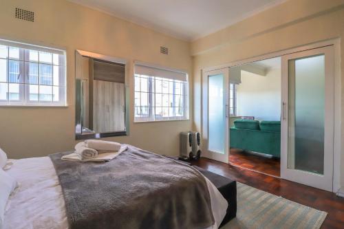 - une chambre avec un lit, un canapé et des fenêtres dans l'établissement Eaton Square 2 by CTHA, au Cap