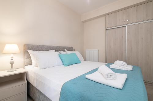 a bedroom with a large bed with towels on it at Emyria-Ground Floor Apartment in Zakynthos Town