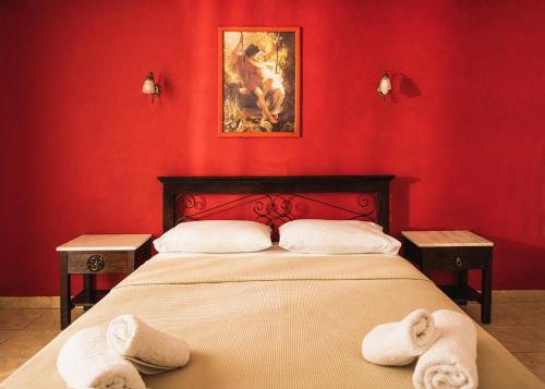 a red bedroom with a bed with towels on it at Sea View Hotel in Alykes