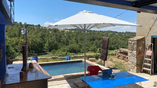 - Piscina con sombrilla y mesa con ordenador en Cal Talaia, en La Glorieta