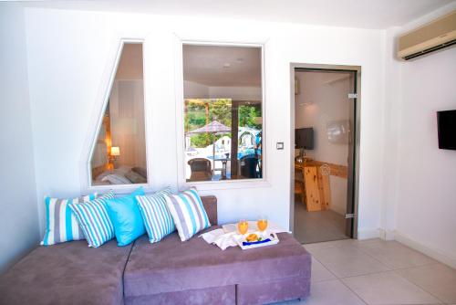 a living room with a couch with pillows at Acrotel Athena Pallas in Elia