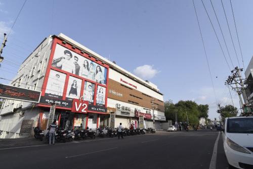 een groot gebouw met motorfietsen geparkeerd aan de kant van de straat bij Hotel Clove in Bijapur