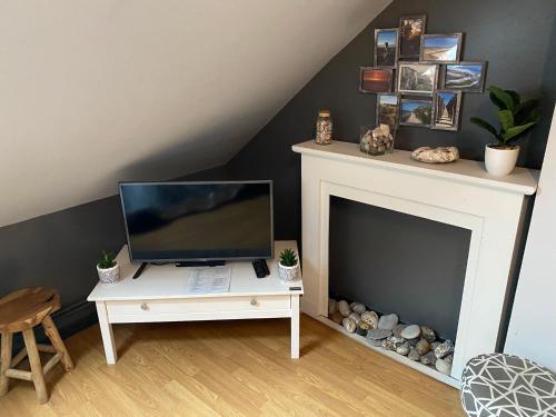 een woonkamer met een tv en een open haard bij appartement romantique tout confort 4 personnes in Boulogne-sur-Mer