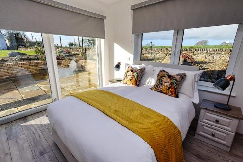 ein Schlafzimmer mit einem großen Bett und einem großen Fenster in der Unterkunft Aghadoe Lodge in Killarney