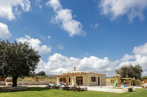 MelidhónionにあるUnique, stonebuilt, rural villas with private pools!の椅子と遊び場付きの建物