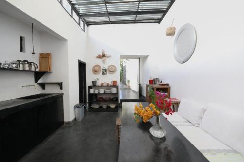 a kitchen with a table with a vase of flowers on it at El Manzar in Oualidia