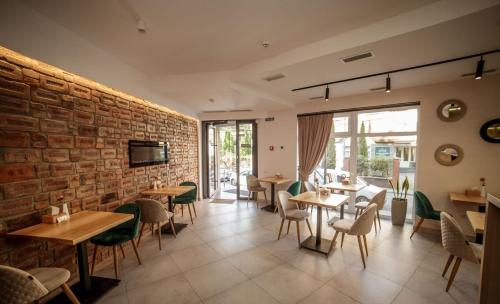 restauracja ze stołami i krzesłami oraz ceglaną ścianą w obiekcie Sunrise Aparts w mieście Polyana (Polana)