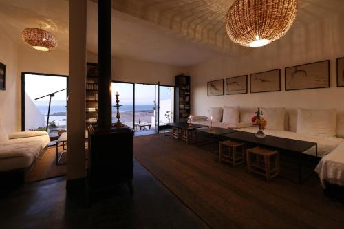 ein Wohnzimmer mit einem Sofa und einem Tisch in der Unterkunft El Manzar in Oualidia