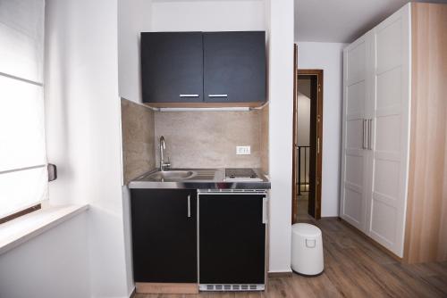 a small kitchen with black cabinets and a sink at Old Town Inn in Pula