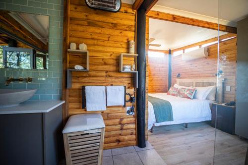 a bedroom with a bed and a bathroom with a shower at Windsong Living The Nest in Krugersdorp