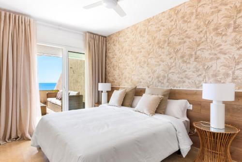 a bedroom with a large white bed and a window at Beach apartment with terrace and private parking in Radazul