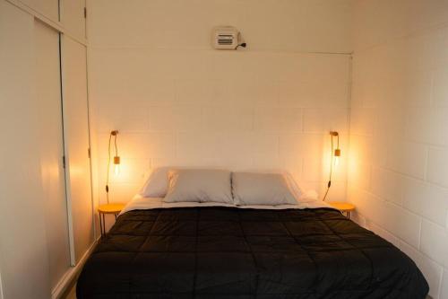 um quarto com uma cama com duas luzes em duas mesas em Hermoso y cómodo alojamiento con patio en Nuñez em Buenos Aires