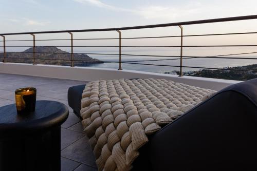 a bed on a balcony with a view of the ocean at Fedra Suites in Plakias