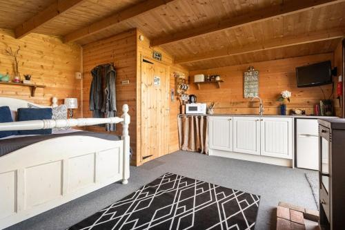 a room with a bed and a kitchen in a cabin at Secret & Secluded Sedlescombe in Battle