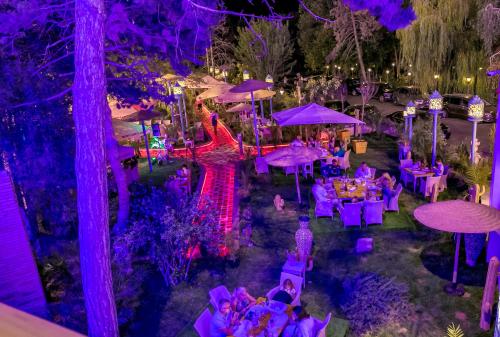 una fiesta en el jardín con iluminación púrpura y mesas en Phoenicia Blue View, en Olimp