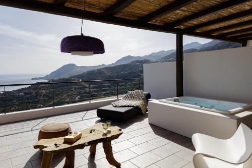 a bathroom with a tub and a view of the ocean at Fedra Suites in Plakias
