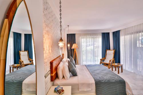 a bedroom with a large bed and two chairs at Arnna Hotel in Kas