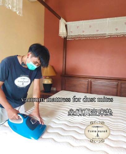 a man is ironing a bed with a mask at Wualai Sabaidee in Chiang Mai