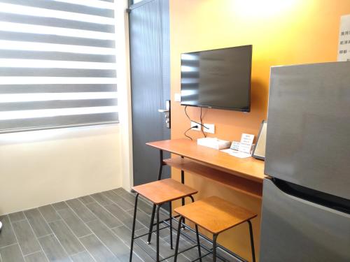 a kitchen with a desk with two stools and a refrigerator at 里Mi背包青旅 Hostel in Fuli