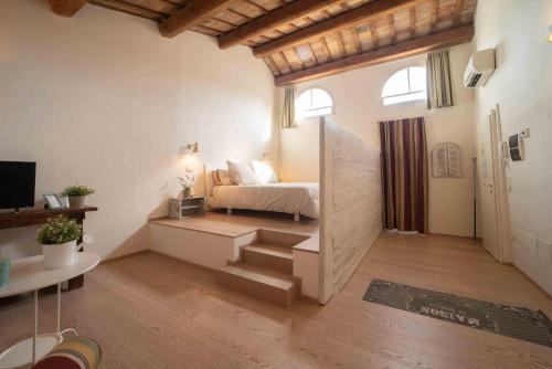 een slaapkamer met een bed en een trap in een kamer bij B&B Relais Druda in Cagli