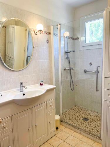 une salle de bain avec un lavabo et une douche avec un miroir dans l'établissement Villa La Muse avec piscine privée et chauffée, à Sablet