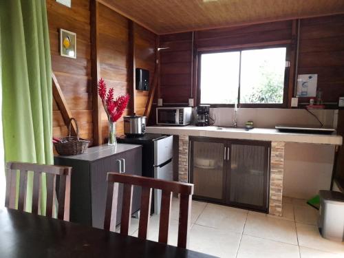 - une cuisine avec des murs en bois, une table et des chaises dans l'établissement Cabaña Rural el Mirador, à Fortuna