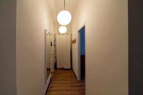 a hallway with white walls and a light fixture at Hbhall Residenze Darsena in Milan