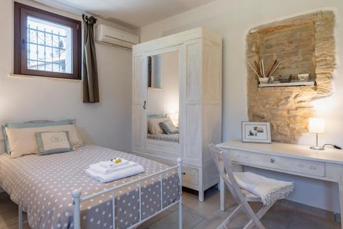 una camera con letto e scrivania con specchio di Il fico nel Pozzo - YourPlace Abruzzo a Fossacesia