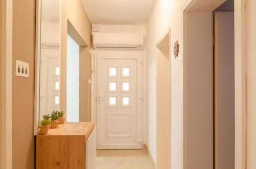 a hallway with a white door and a wooden table at Apartments Ranko in Zavalatica