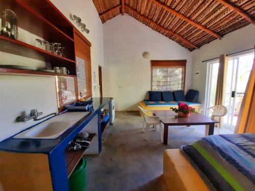 a kitchen with a sink and a living room at Casa Malcampo in Praia do Tofo