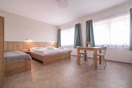 um quarto de hotel com duas camas e uma mesa em Apartmány Vinařství Šebesta em Dolní Dunajovice