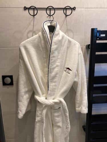a white robe is hanging on a rack at Wine Hôte Chambre d'hôtes in Le Pian-Médoc