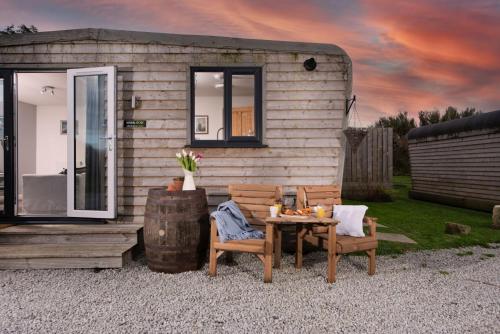 a tiny house with a table and two chairs at Wheal Rose -Beautifully Fitted Lodge Helston Cornwall in Helston