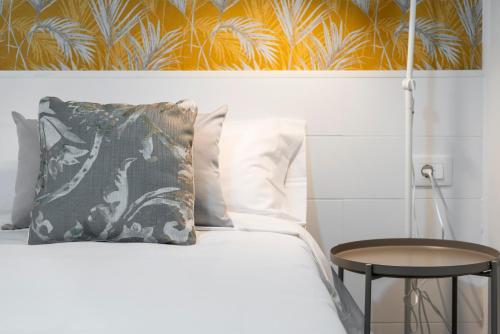 a bed with a pillow and a table next to it at Beach apartment with terrace and private parking in Radazul