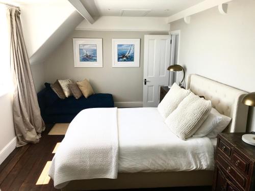 拉姆斯蓋特的住宿－Marina Retreat - Stunning 4 bedroom, 3 bathroom house with harbour views!，卧室配有白色的床和蓝色的沙发