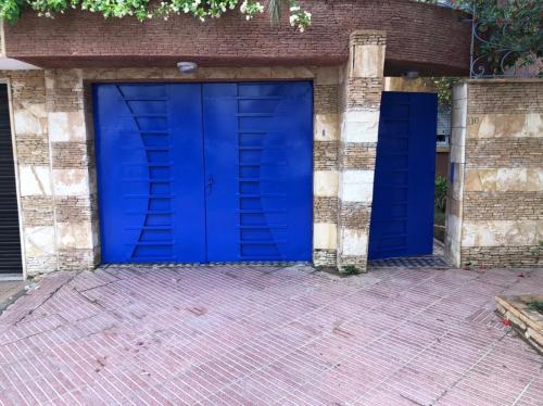 eine blaue Garagentür und ein Backsteingebäude in der Unterkunft Villa Ory in Agadir