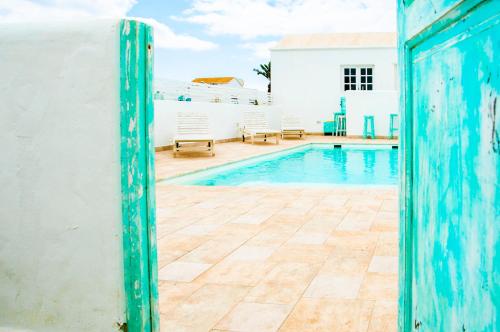 a view of a swimming pool with a blue door at Turquesa Beach&Pool Apartaments in Playa Honda