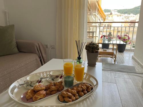 a tray of food on a table with two glasses of orange juice at Theo Suites in Kavala