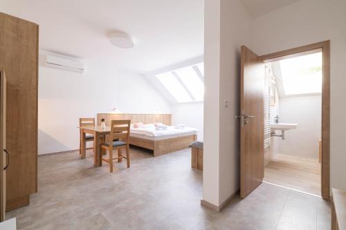 a room with a bedroom and a table and a bed at Apartmány Vinařství Šebesta in Dolní Dunajovice
