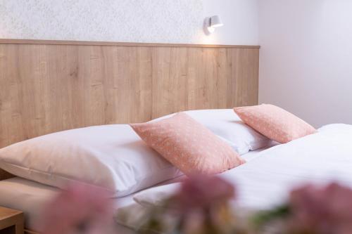 a bed with pink and white pillows on it at Apartmány Vinařství Šebesta in Dolní Dunajovice