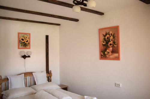 a bedroom with two beds and a painting on the wall at Patakmenti Panzió Spa in Corund