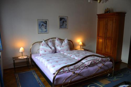 a bedroom with a bed with pillows and two lamps at Sand-Hof 