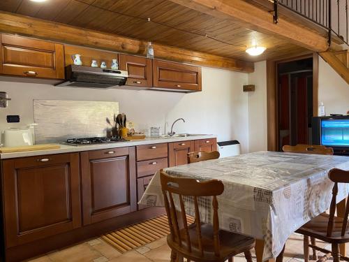 una cucina con tavolo, sedie e piano cottura di Villa dei Vasari a Casoli