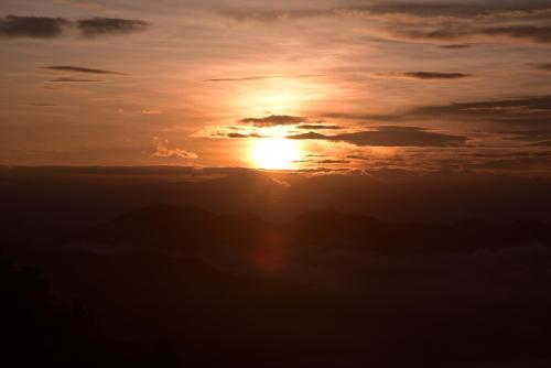 a sunset with the sun setting in the sky at CHILLAX Resorts Palakkayam THATTU in Paithalmala