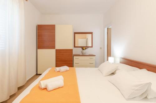 a bedroom with two white beds and a mirror at Apartments Ranko in Zavalatica