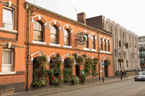 a brick building with plants on the side of it at The Jewellery Suites Birmingham in Birmingham