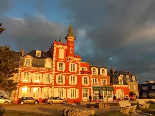 un grand bâtiment orange avec une tour en haut dans l'établissement Les Bains de mer, au Crotoy